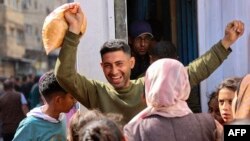 Un palestinian se bucură că a apucat să cumpere pâine subvenționată, la Gaza City, duminică, 14 aprilie. Guvernul Israelului a promis că brutăriile din enclavă vor fi redeschise. 