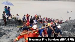U 2020. godini, više od 160 ljudi stradalo je u jednoj od najgorih katastrofa u Hpakantu nakon što se rudarski otpad sručio u jezero (Foto: Spasioci iznose tela poginulih u klizištu rudnika žada, 2. jul 2020.)