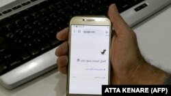 A man holds a smartphone connected to a Wifi network without internet access at an office in the Iranian capital Tehran on November 17, 2019.