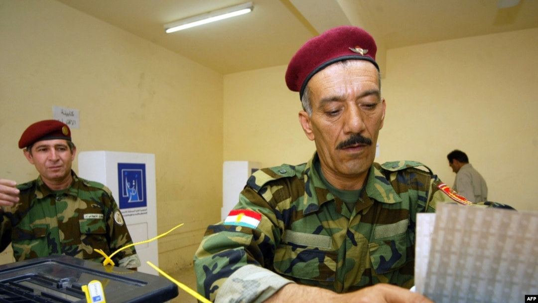 An Iraqi Kurd peshmerga drops his ballot at a polling station in Irbil