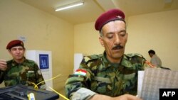 Kurdish peshmerga militia officers vote in Irbil. With a third of the seats, the opposition in the region has challenged the duopoly of the two ruling parties.