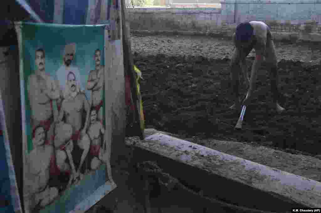 During a coronavirus lockdown in Lahore, Pakistan, a wrestler prepares the ground as part of his training for the national sport of Kushti. (AP/K.M. Chaudary) &nbsp;