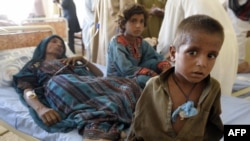 An injured Pakistani woman is surrounded by her children at a makeshift hospital in the earthquake-devastated Awaran district of Balochistan Province. 