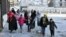 Civilians who evacuated the eastern districts of Aleppo carry their belongings as they arrive in a government-held area on December 7.