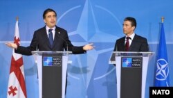NATO Secretary-General Anders Fogh Rasmussen (right) has told Georgian President Mikheil Saakashvili (left) that NATO is still firmly behind the Caucasus country joining the alliance one day (file photo).