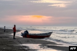 Një person qëndron pranë një varke në brigjet e Kaspikut në Sorkrud të Iranit më 24 mars 2026.