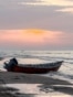 A man stands near a boat moored along a beach on the Caspian Sea coast in Sorkhrud in Iran's northern Mazandaran province on March 24, 2026, where many families have relocated due to the ongoing war with the US and Israel.