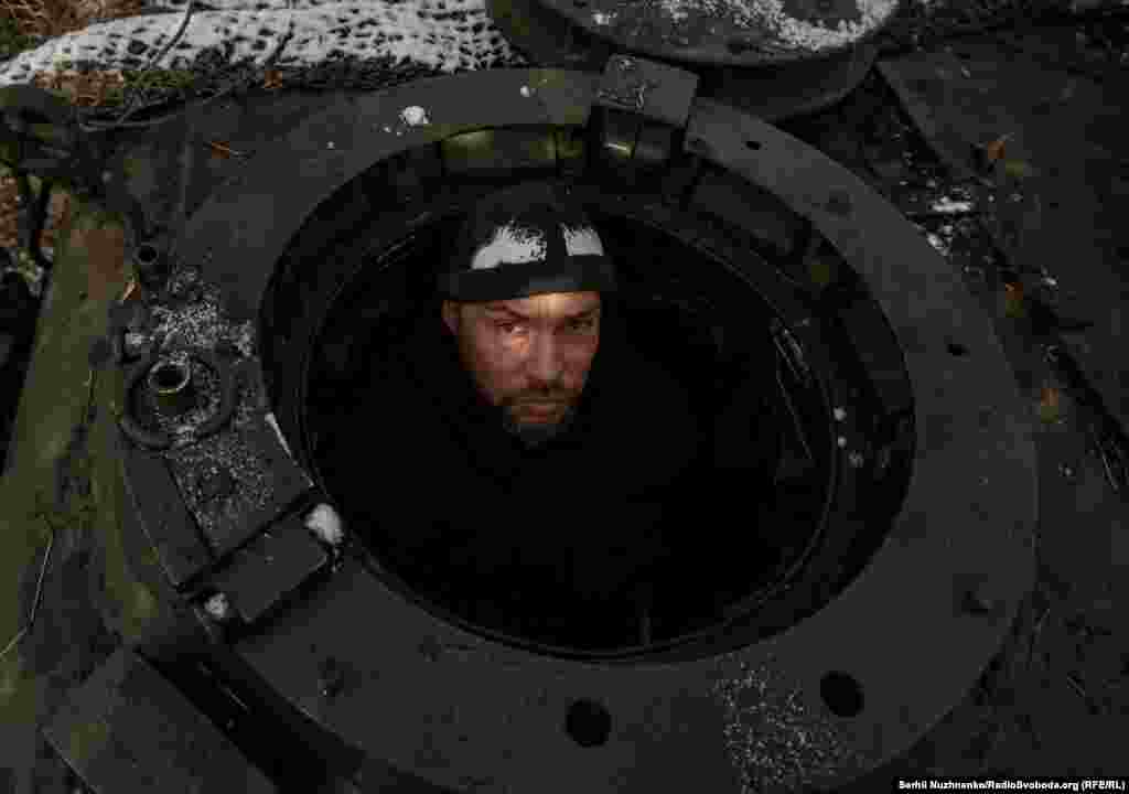 A Ukrainian soldier stares out of the entrance hatch of a Leopard 1A5 tank near the front line in the Donetsk region.