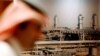 A Saudi official stands in front of a giant Saudi oil industry picture at a hotel in the Red Sea port city of Jiddah, Saudi Arabia, on Saturday, June 21, 2008, ahead of a major oil summit.