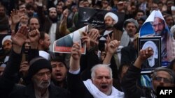 Afghan Shi'a hold posters and chant slogans during a demonstration in Herat on January 3.