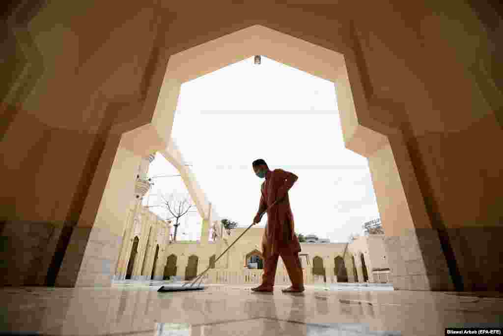 Мужчина убирает мечеть перед священным месяцем Рамадан в Пешаваре, Пакистан