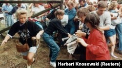 Est-germani fugind din lagărul comunist în spațiul european prin gardul care separa Ungaria de Austria lângă Sopron. 19 august 1989