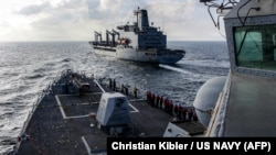 Эсминец с управляемыми ракетами класса «Арлей Берк» идет рядом с танкером-заправщиком флота во время пополнения запасов в Аравийском море, февраль 2026 года