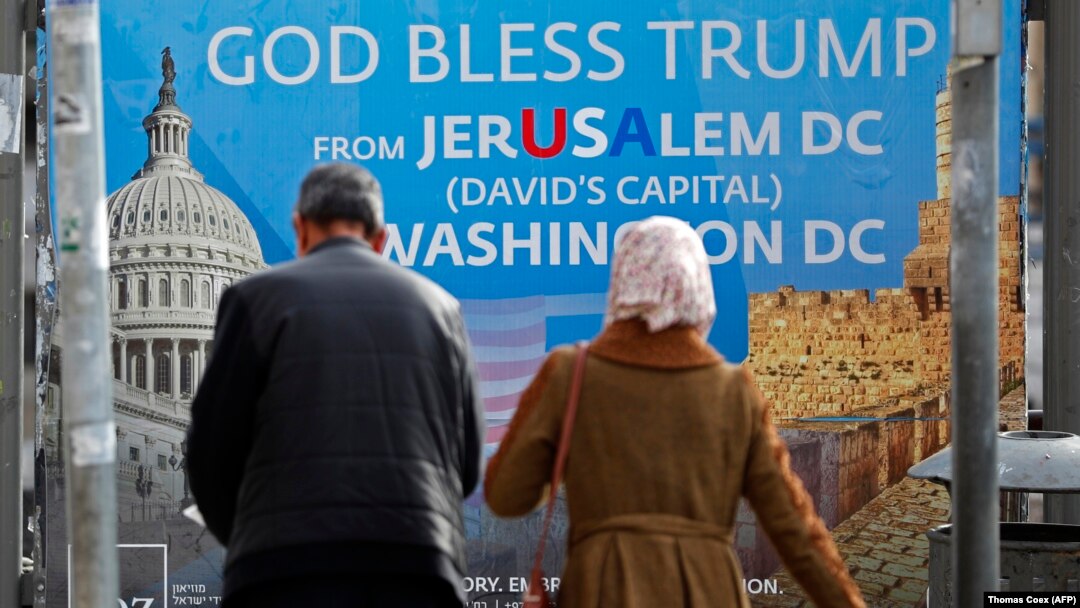 Palestinski par prolazi pored plakata u Jerusalimu