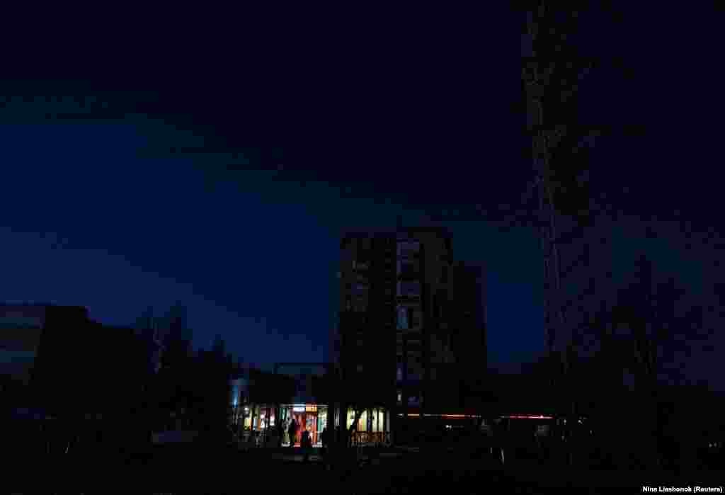 Жителі Одеси стоять біля одного з ресторанів, який працює на генераторі, під час відключення електроенергії у більшій частині міста після того, як критично важлива цивільна інфраструктура постраждала від нещодавніх російських атак ракетами та безпілотниками, про що повідомила українська влада. Одеса, 13 грудня 2025 року