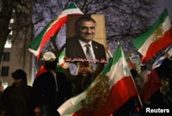A woman holds up an image of Reza Pahlavi, the exiled son of the last shah of Iran, as Stop the Hate UK holds a protest calling on Prime Minister Keir Starmer to support the Iranian people, in London on January 11.