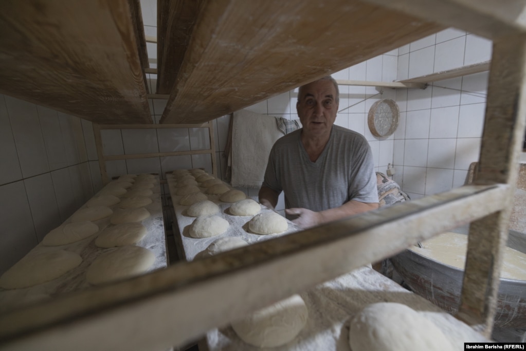 Kulaçe të vendosura në rafte që presin për t’u futur në furrë për pjekje, para se të shiten tek myshterinjtë që presin me padurim pranë furrës.
