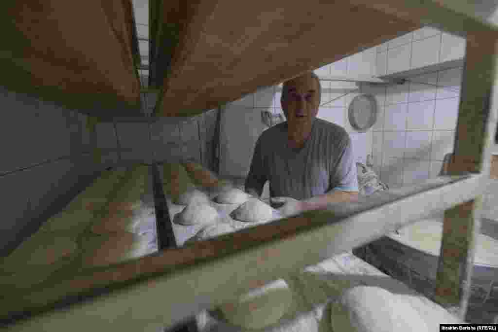 Kulaçe të vendosura në rafte që presin për t’u futur në furrë për pjekje, para se të shiten tek myshterinjtë që presin me padurim pranë furrës.