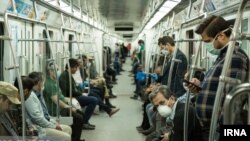 Commuters wearing masks against coronavirus on Tehran underground (Metro) on April 7, 2020. 