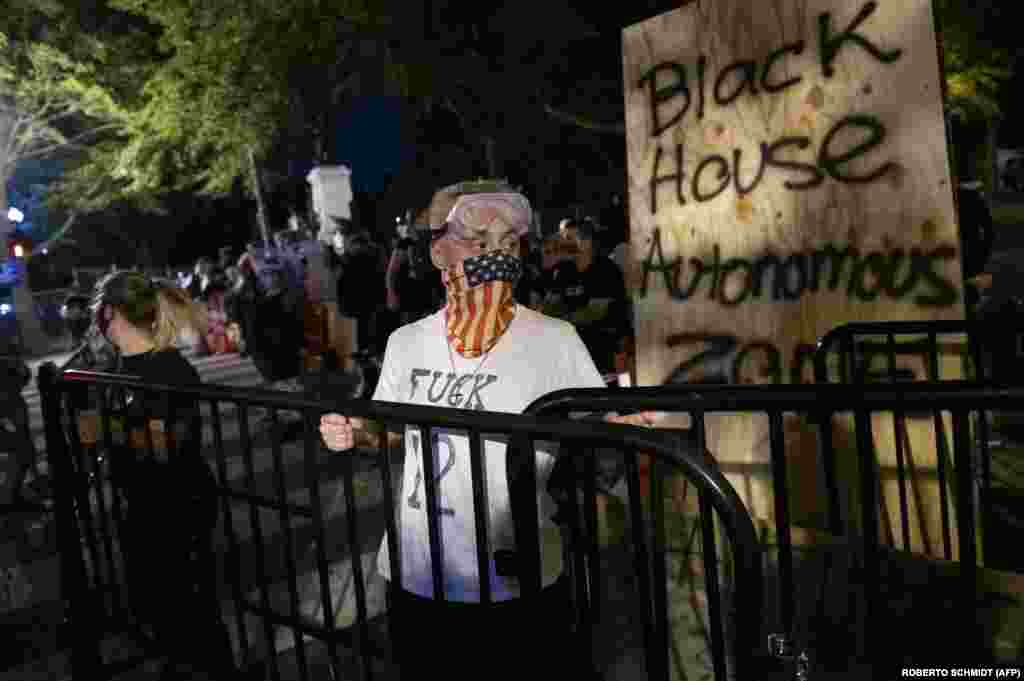 Протестувальники несуть металеві огорожі, щоб зміцнити барикаду, яку вони встановили і позначили написом &laquo;Автономна зона Чорного дому&raquo; перед парком Лафеєт біля Білого дому у Вашингтоні, округ Колумбія