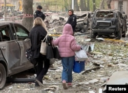 Residents leave the site of an apartment building hit by a Russian drone and missile strike amid Russia’s attack on Dnipro.