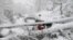Vehicles stuck under fallen trees are seen on a snowy road, in Murree, Pakistan, on January 8.