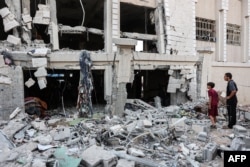 A man and boy inspect destruction in the aftermath of Israeli bombardment on a school in Gaza City on October 2.