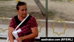 Awtobus duralgasynda oturan zenan.