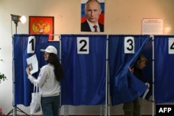 People vote in Russia's presidential election at a polling station in Donetsk, Russian-occupied Ukraine, on March 16.