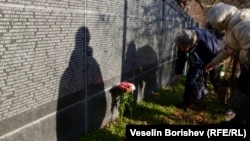  Жени сервират цветя пред Мемориала на жертвите на комунистически режим в София. 