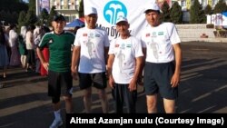 Ош-Ташкент марафонунун катышчуулары Сатвалды Хусанов, Зулумбек Хабибуллаев, Курсанбек Сыдыков жана аларды сүрөөнгө алган ФИФА калысы Бахадыр Кочкаров. Ош, Кыргызстан. 27-август, 2018-жыл. 