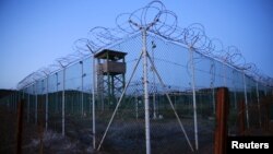 Chain link fence and concertina wire surrounds a guard tower within Joint Task Force Guantanamo's Camp Delta at the U.S. naval base in Guantanamo Bay, Cuba.