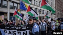 Policajci stoje pored aktivista aktivista sa palestinskim zastavama ispred Demokratske nacionalne konvencije u Chicagu, Illinois, SAD, 18. avgusta 2024.