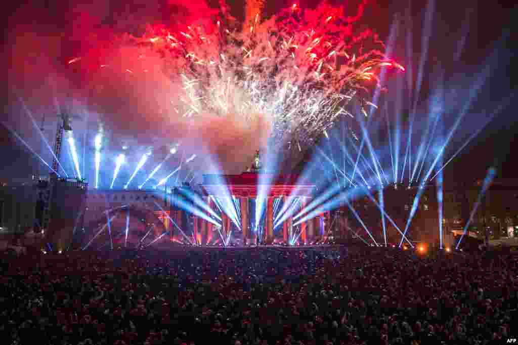 People watch fireworks in front of the Brandenburg Gate during a street party organized by the German government to mark the 25th anniversary of the fall of the Berlin Wall. (AFP/Todd Andersen)