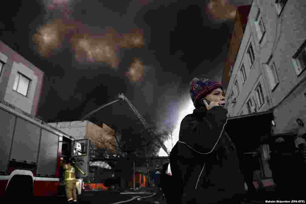 A boy walks on a Moscow street as Russian firefighters extinguish a burning warehouse on the southern outskirts of the city on December 13. (Reuters/Maxim Shipenkov)