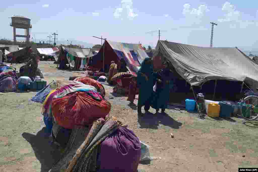 Afghan women stand outside their tents on the outskirts of Chaman on September 1.