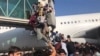 People try to board a plane at the airport in Kabul on August 16.