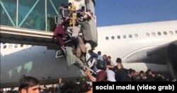 Люди пытаются попасть на борт самолета в в аэропорту имени Хамида Карзая в Афганистане.