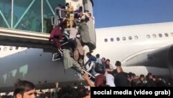 Afgani disperați iau „cu asalt” un avion american de transport care tocmai încearcă să decoleze de pe aeroportul din Kabul, Afganistan, luni, 16 august 2021.