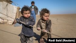 Internally displaced Syrian children who fled Raqqa stand near their tent in Ras al-Ain Province in January 2017.