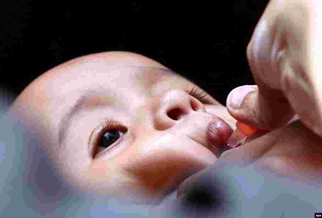 Health workers administer polio vaccinations during a three-day vaccination campaign in Karachi, Pakistan. Pakistan is one of the last two countries, along with Afghanistan, where polio is still endemic. Though new polio cases dropped to a nine-year low in 2015, attacks by Islamist militants against health workers and police guarding them remain a challenge for the UN-funded vaccination campaign. (epa/Rehan Khan)