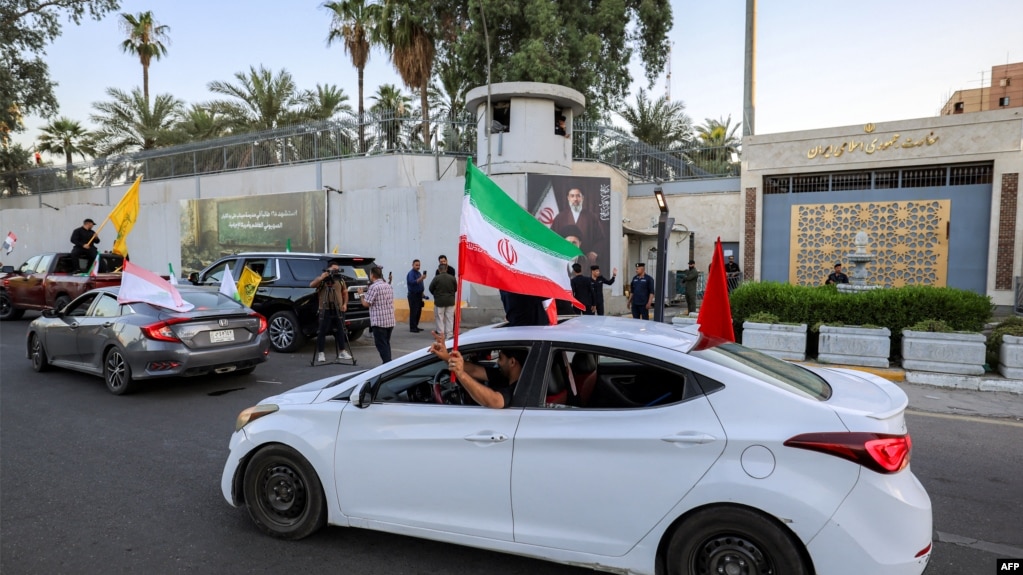 رژه طرفداران جمهوری اسلامی با پرچمهای حزبالله و سایر گروههای نیابتی تهران در مقابل سفارت ایران در بغداد