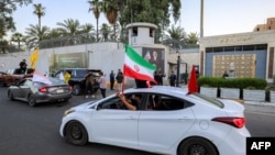 رژه طرفداران جمهوری اسلامی با پرچم‌های حزب‌الله و سایر گروه‌های نیابتی تهران در مقابل سفارت ایران در بغداد