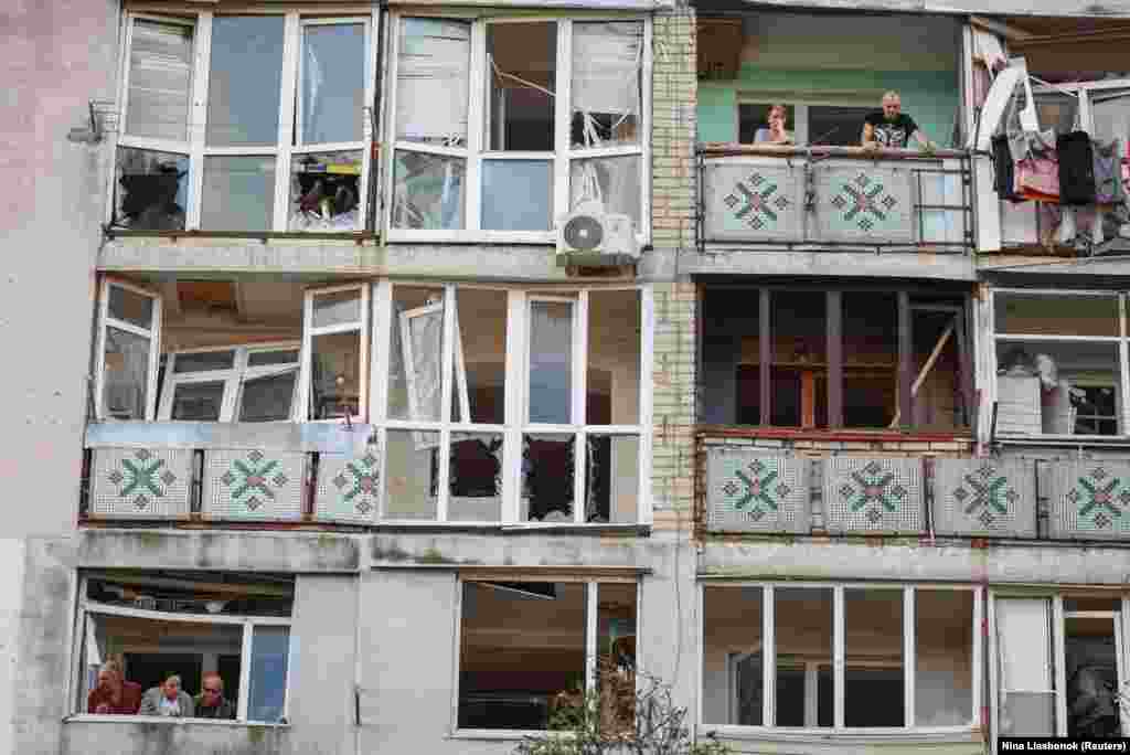 Residents stand on the balconies of an apartment building damaged by a Russian drone strike in the city of Chornomorsk in Ukraine&#39;s Odesa region.