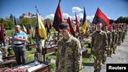 Ukrajinski vojni kadeti obilaze grobove ukrajinskih vojnika koji su poginuli tokom ruske invazije na Ukrajinu da bi obeležili pravoslavni praznik Cvetne nedelje na Ličakovskom groblju u Lvivu 28. aprila 2024.