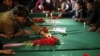 A man places a candle on top of one of the coffins for the seven people killed by unknown militants, during a protest procession in Kabul.