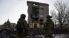 Militari ucraineni lângă o clădire cu apartamente grav avariată de un atac militar rusesc în Bahmut 