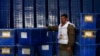 An Afghan Election Commission worker stands by ballot boxes and election material at a warehouse in Kabul. Turnout is expected to be much higher than in 2009.