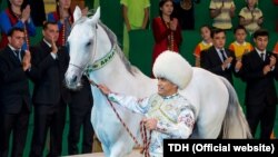 Туркманлар Акхан отини ўринларидан турган ҳолда гулдурос олқишлар билан кутиб олмоқда.
