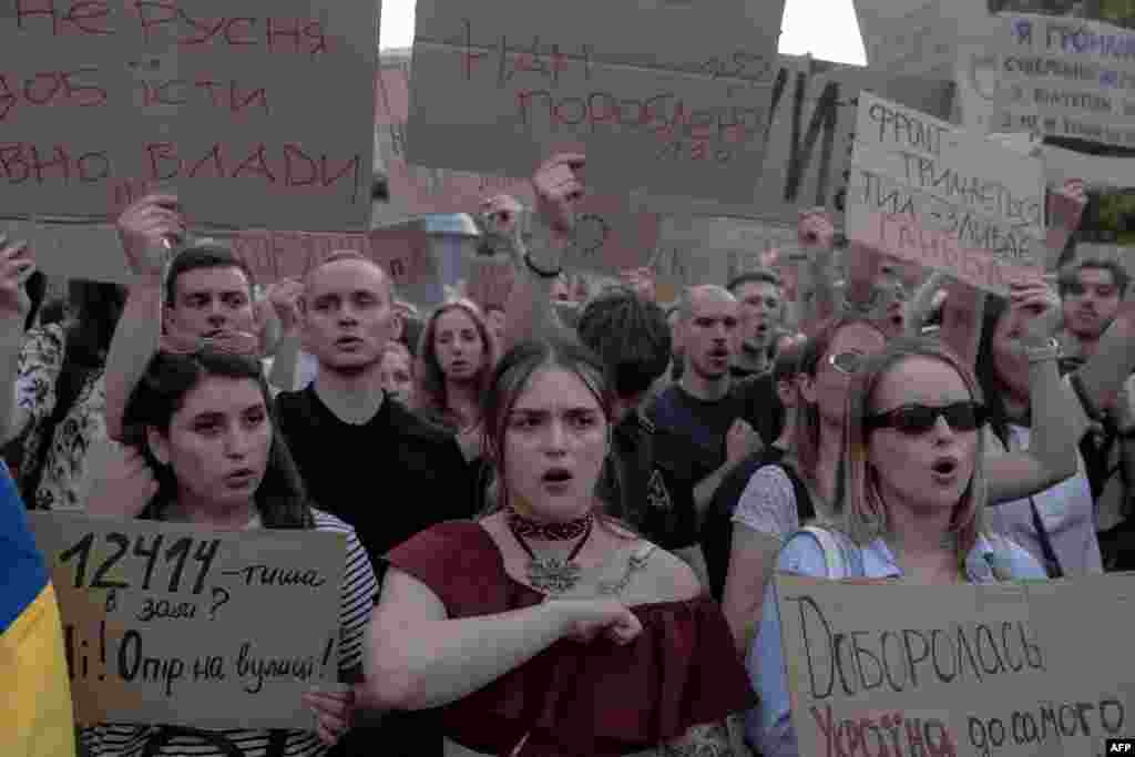 Protesters hold placards during a demonstration against a law that would remove the independence of two key anti-corruption bodies, in downtown Kyiv on July 23.